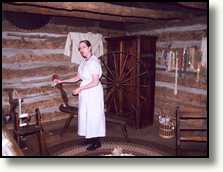 Dame in Log Cabin Village vertelt iets over het leven en werken van vroeger